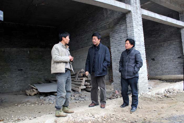 局党委书记、局长（中）在海马村察看地灾搬迁户的新房建设情况。