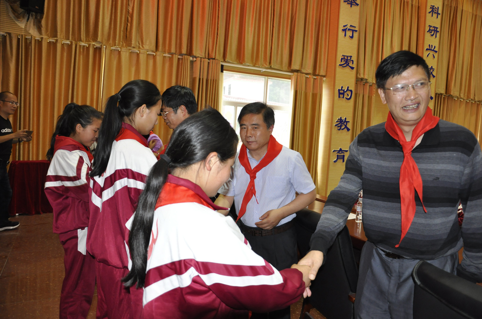 学生们为来自省城的伯伯们戴上红领巾（林小会摄）