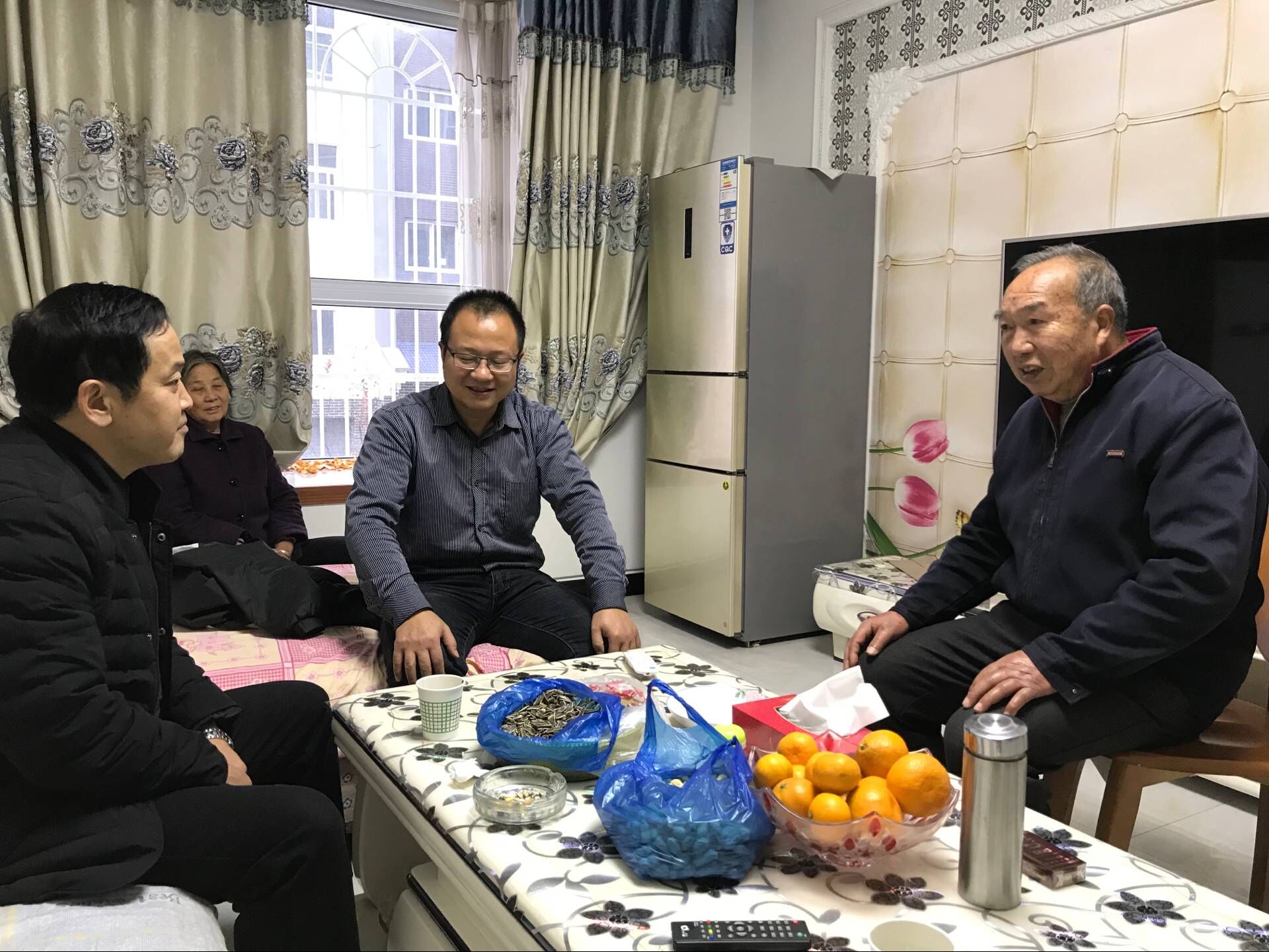 队工会主席魏吉荣同志与退休老职工袁简华及家人亲切交谈（谢方旭