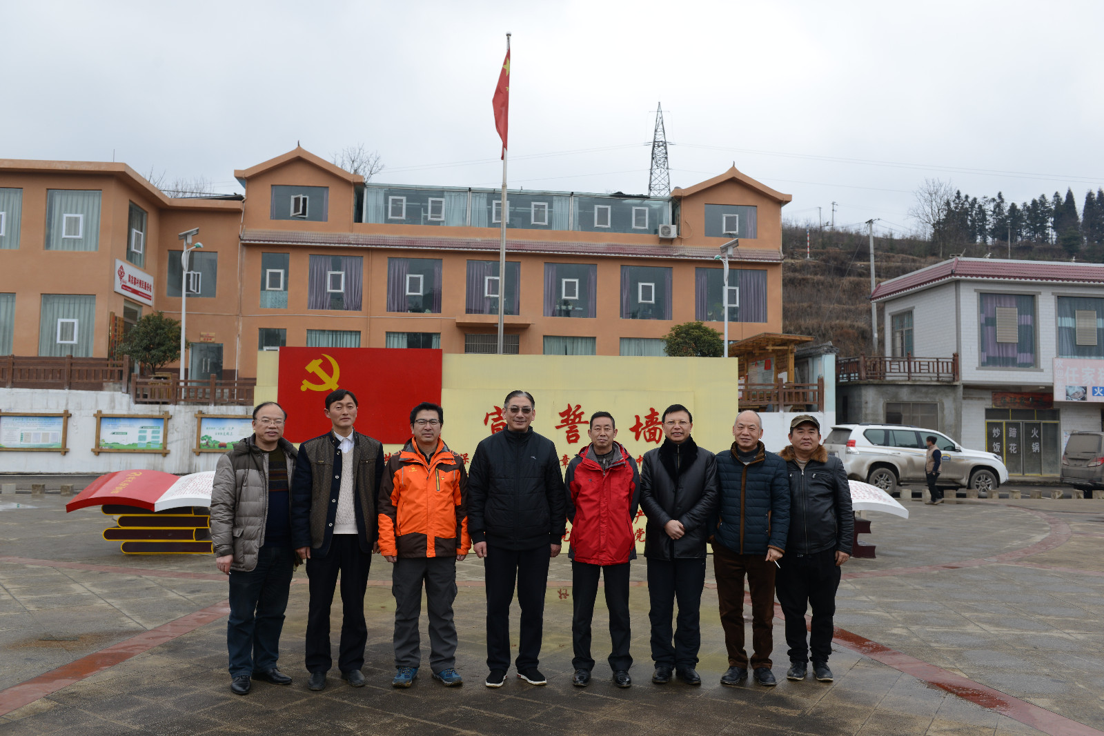 慰问组与驻村干部和村支两委在宣誓墙前合影留念