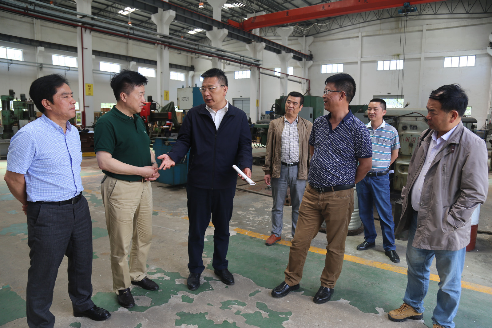 图为张淼在探矿厂车间了解选矿产品的生产、市场销售情况